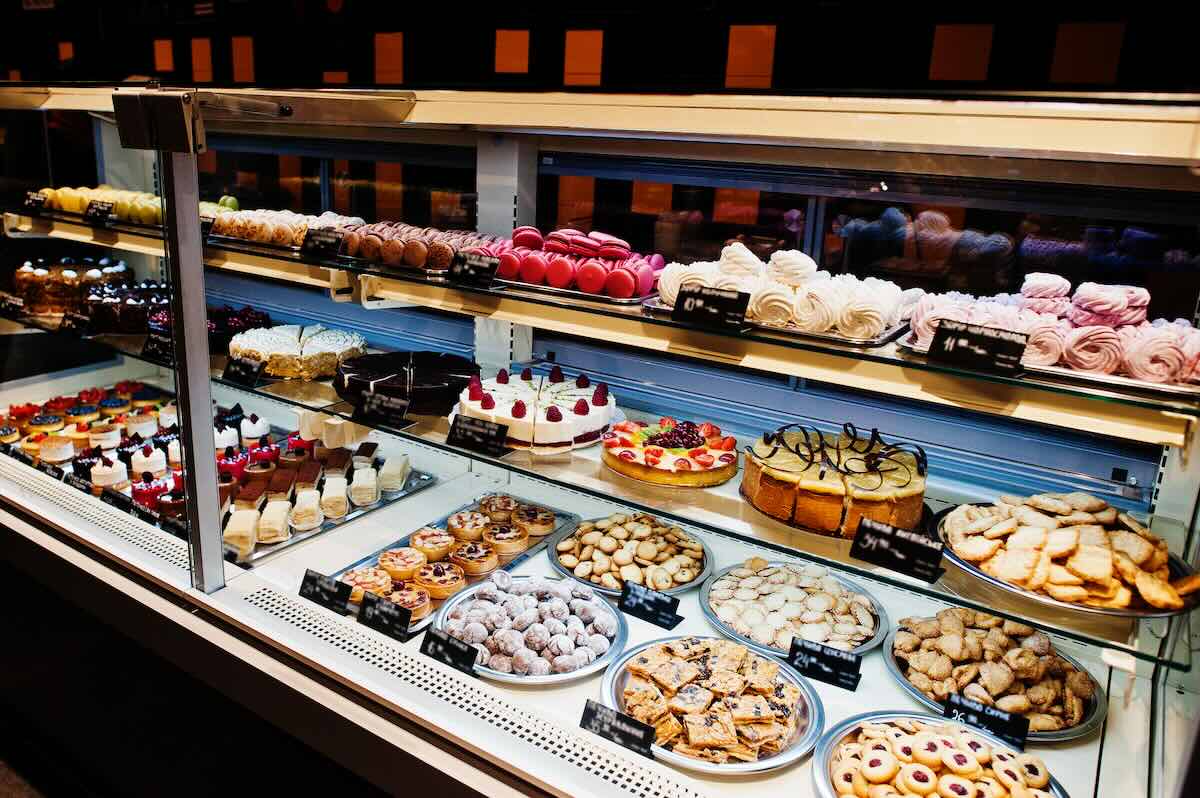 Various cakes on supermarket shelves for sale.